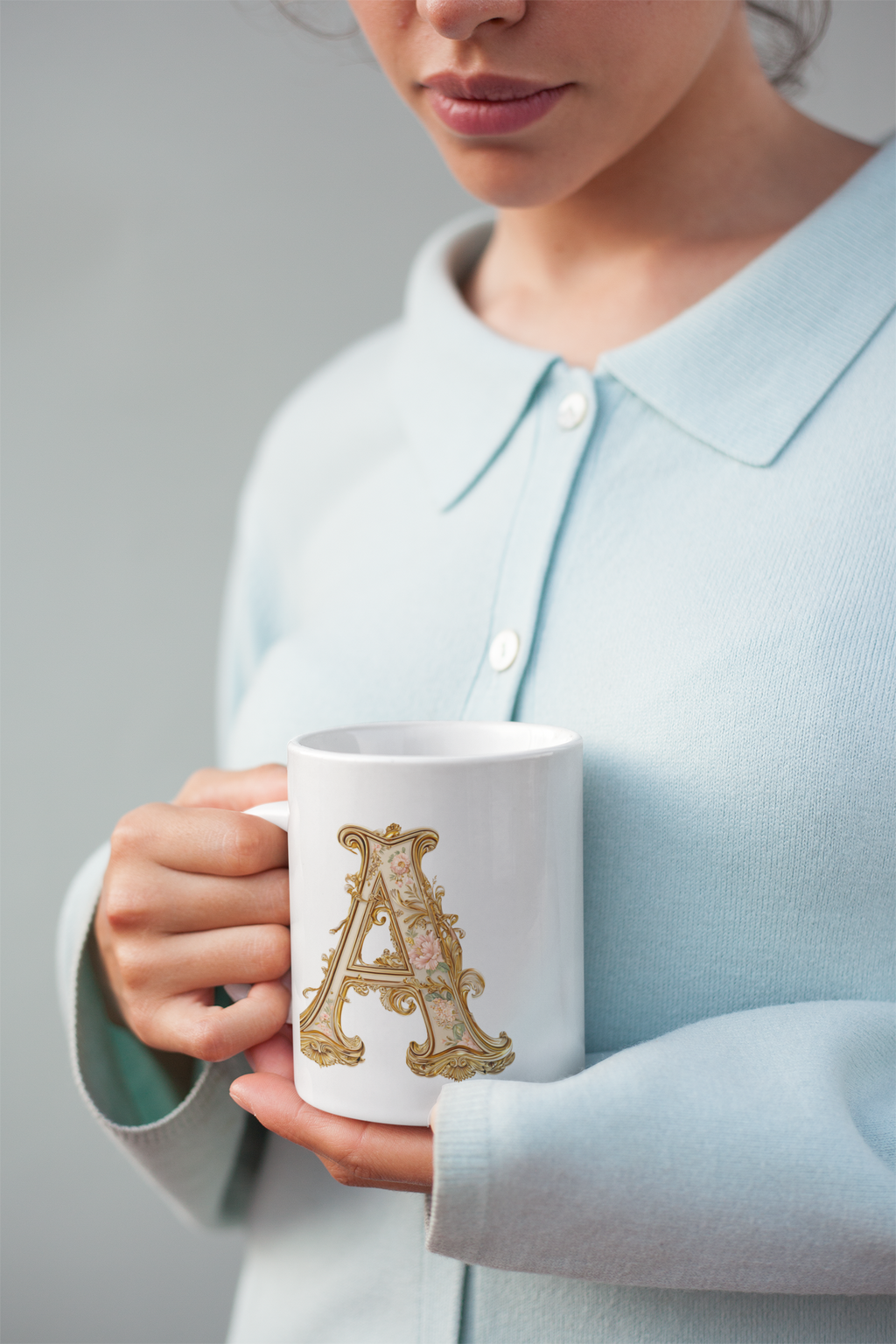 coffee mug held by a woman wearing a blue sweater