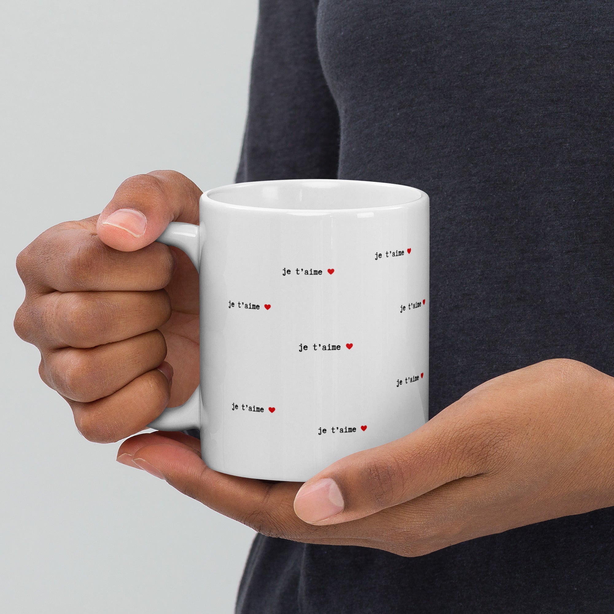 Hands holding 11 oz white je t'aime mug